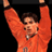 Pixelated static image of a person in an orange sports uniform with arms raised against black background, likely representing a soccer player celebrating.
