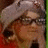 Pixelated image of a person with light brown hair wearing glasses and a red garment, next to stylized text reading Dork Face Lily on white background.
