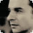 Pixelated grayscale close-up of a person's face in profile, showing the right side of the head with visible eye, nose, and mouth against a dark background.