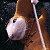 A pixelated contact sheet showing two frames of an animated icon featuring a brown and white dog-like character with earphones on the left side, next to green text reading "Original Icons .com" on a dark background.