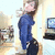 Pixelated image of a person in blue clothing holding an object, with blurred background elements including a screen and furniture.