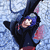 A character with blue hair and a dark hooded outfit lies on a light blue patterned background, head tilted back.