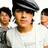 Pixelated image of a person in a flat cap with two blurred figures behind, paired with text blocks on black and gray backgrounds.