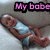 Pixelated image of a person lying down with text 'My babe' in pink block letters above, set against a gray background.