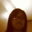 Pixelated image of a person with long brown hair and glasses against a light background.