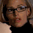 Four pixelated show a person with light brown hair and glasses in different poses against dark backgrounds