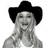 Pixelated grayscale image of a person wearing a black cowboy hat with visible facial features and hands clasped near the chest against a white background.