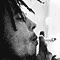 Black-and-white pixelated image of a person's face in profile with visible facial features and hair, accompanied by a small figure holding an object on the right side.