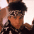 A pixelated image of a person with dark hair and patterned headband, overlaid with white text on black backgrounds.