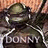 Pixelated image of a dark-colored vehicle with visible headlights and a partially obscured text label beneath it on a gradient background.