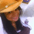 Pixelated image of a person wearing an orange hat and dark clothing, with visible facial features including closed eyes and pink lips.