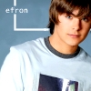 A person with brown hair wearing a light gray shirt with dark gray collar and a graphic print on the chest, standing against a blue background with white text reading 'efron' and a white L-shaped line.