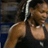 Pixelated static image of a tennis player in mid-swing with racket and ball, wearing dark top and light shorts against blurred background.