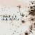 Pixelated static image with scattered dark brown and black pixels on a light beige background, featuring partial text fragments and abstract shapes.