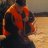A pixelated static image shows a figure in dark clothing holding an orange object against a blurred background with warm tones.