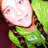 A person with long brown hair and blue eyes appears in multiple poses: wearing a green top, making a heart shape with hands, and in a group with others.