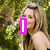 A woman with long blonde hair stands outdoors against green foliage, with text overlays changing from 'I' to 'Love' and 'Ashley Tisdale' in purple.