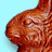Animated sequence of a brown chocolate bunny with textured surface against light blue background, showing head turning from left to right.
