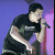 A man in a black t-shirt sings into a microphone against purple and pink background, with green text reading "-Pierre Bouvier" visible.