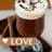 A pixelated image shows a dark brown beverage in a glass with white foam, held by hands wearing blue and white checkered fabric. A light brown banner below displays 'LOVE' text next to a heart symbol.
