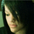 Pixelated close-up of a person's face with dark hair, light skin tone, and subtle facial features against a dark background.