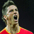 Pixelated close-up of a person with short dark hair wearing red and yellow clothing against a black background.