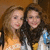 Two people with long hair stand side-by-side in a pixelated image, one wearing an orange top and the other in white with blue accents.