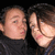 Two people in dark turtlenecks pose closely together against a black background, with one person's head turning left to right across frames.