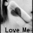 Black-and-white pixelated icon shows a heart-shaped object on a stick against light background with 'Love Me' text at bottom.