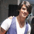 Pixelated image of a person with dark hair wearing white and blue clothing against a dark background.