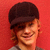 Static 50x50 pixel icon showing a person with brown hair and dark cap against solid red background, rendered in low-resolution pixel art style.