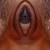 A pixelated close-up of a human eye with a dark pupil and blue iris, framed by reddish-brown eyelids and surrounding skin tones.