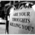 Black-and-white image of a person holding a sign with text, partially obscured by dark hair and background elements.