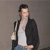 Pixelated figure in dark jacket and white shirt holding a light-colored object against a neutral background.
