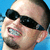 Two side-by-side pixelated images of a man with short dark hair, one wearing black sunglasses against blue background and the other without sunglasses against white background.