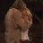 Pixelated figure with light skin tone, dark hair, and a white garment against a dark background.