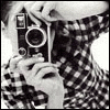 Black-and-white image of a person in a checkered shirt holding a vintage camera, with visible animation changes in the camera lens and hand position across six