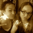 Two people with light brown hair pose closely together in a pixelated image, one holding a bright white star-shaped object near their face.