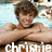 A person with brown hair in a pool setting, arms crossed over chest, smiling at camera.