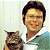 Pixelated static image of a person in a white shirt holding a cat, with light background and visible dithering.
