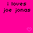 A bright pink background displays repeated text "i loves joe jonas" with small pixelated hearts scattered across the image.