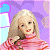 A pixelated contact sheet showing two frames of an animated icon featuring a blonde doll in a pink striped sweater against a purple background with green text reading "Original Icons .com" on the right.