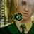 A person with light brown hair in a green outfit with a white collar, wearing a green pixelated symbol on their chest, shown in two side-by-side frames with a slight facial expression change.