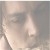 Pixelated grayscale image of a person's face with closed eyes, light skin tone, and visible facial features including nose and mouth, set against a neutral background.