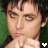 A 48x48 pixel animated contact sheet showing two side-by-side frames of a person with dark hair and light skin, hands clasped near the chin against a green background, with a white heart symbol at the bottom center.