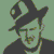 Pixelated icon of a figure with dark hair and beard, wearing a dark hat and shirt against a light green background.