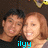 Two people with light brown hair pose closely together against a dark background, with blue text below them.