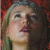 A pixelated image of a woman with light brown hair and red lips, looking upward against a red patterned background, with text overlays changing between frames.