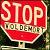 A pixelated red stop sign icon with white text and a greenish lower section, displayed on a dark background.