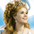 Pixelated image of a person with curly brown hair, light skin, and a blue halo against a light blue background.